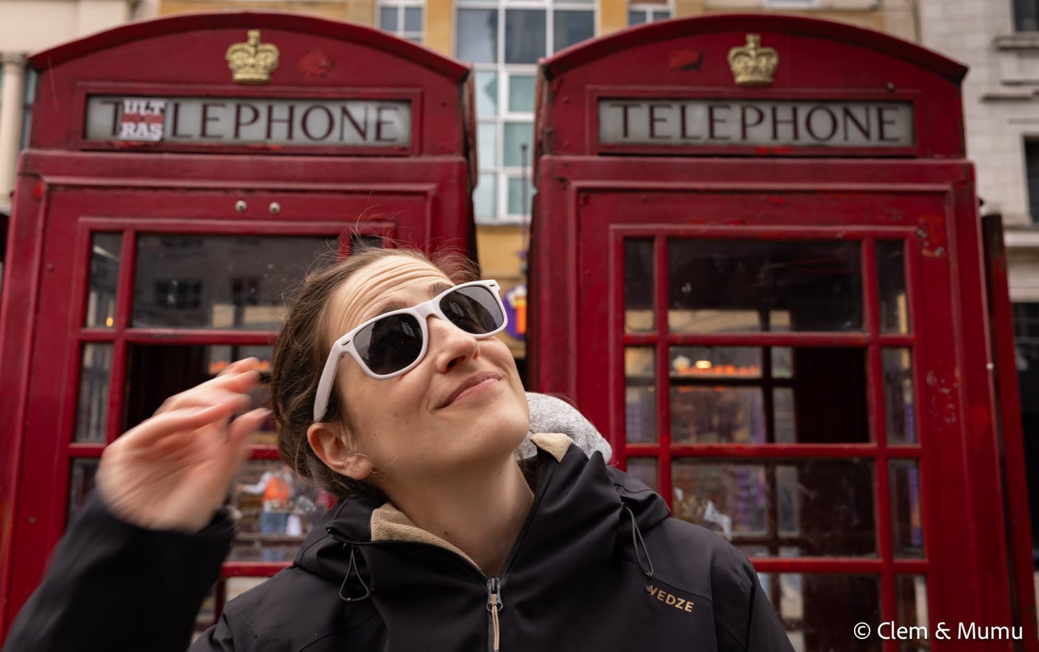 Clem à Londres devant les cabines téléphoniques rouges.